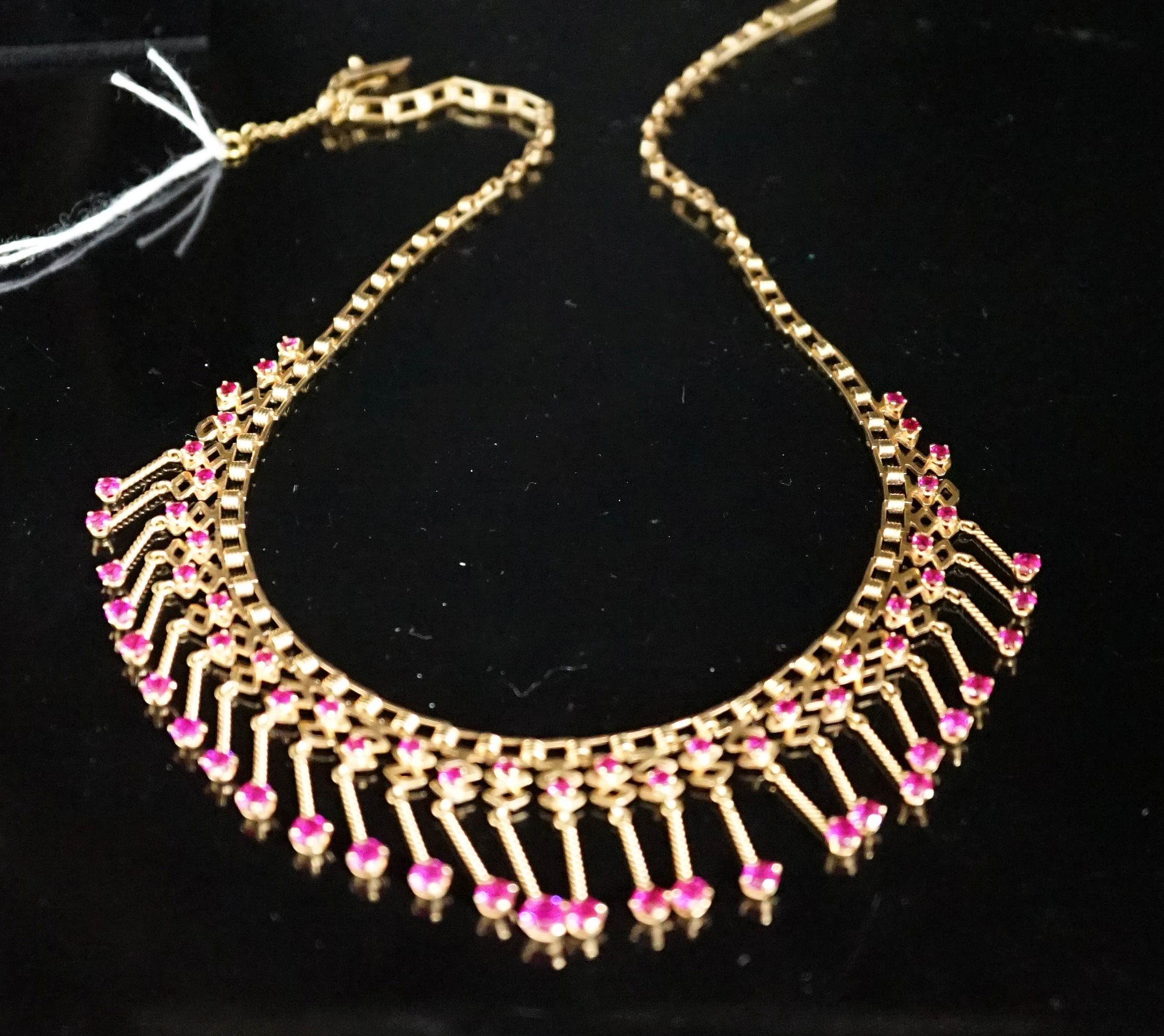 A modern yellow metal (stamped 18) and synthetic ruby? set drop fringe necklace, 41cm, gross 35 grams.